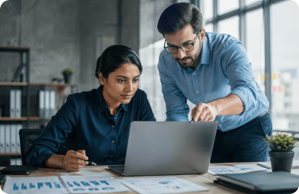 Two colleagues working through analytics on a laptop
